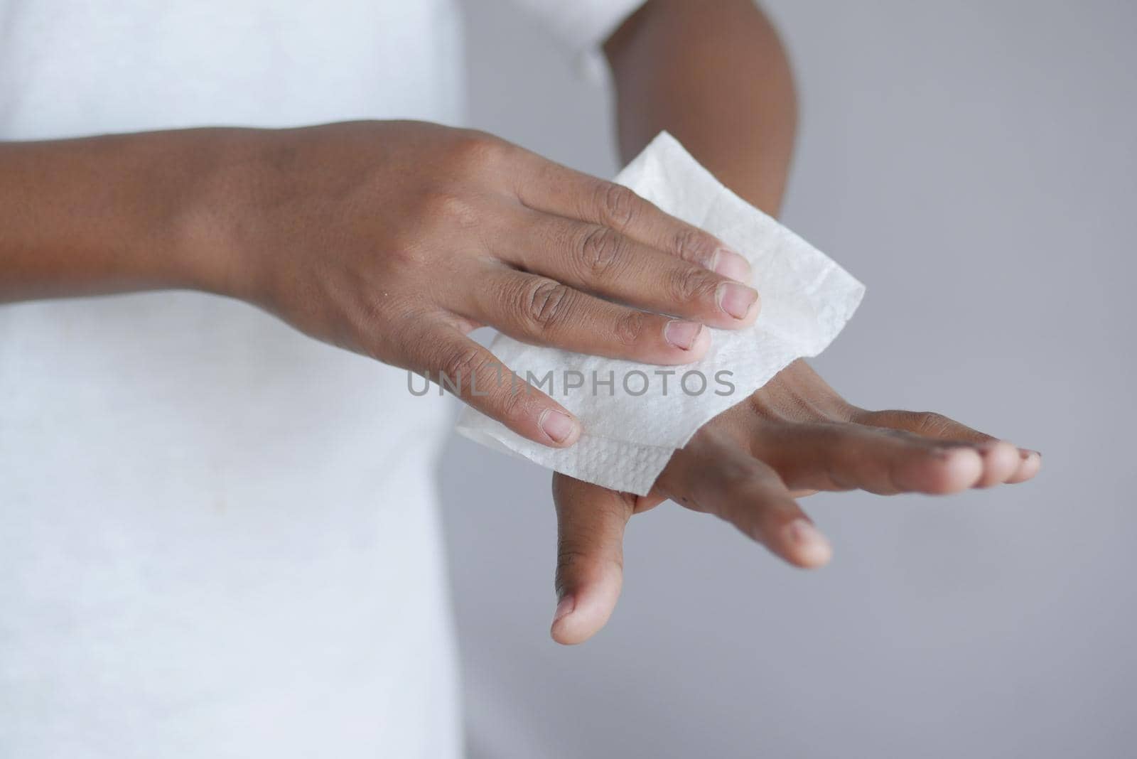 man disinfecting his hands with a wet wipe