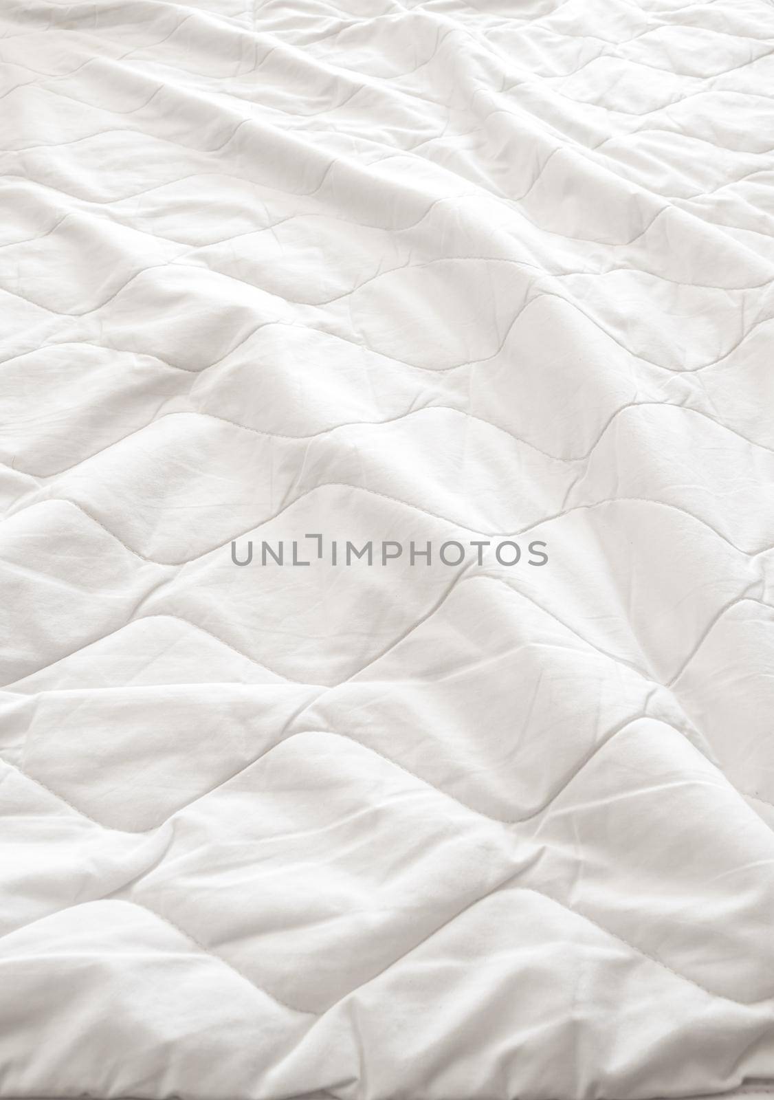 White blanket crumpled on the bed by Satakorn