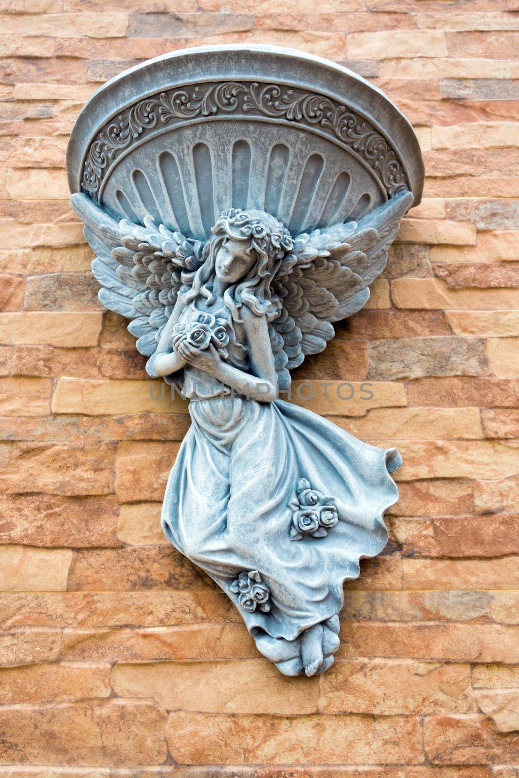 Fairy statue and fountain basin decorated on the wall