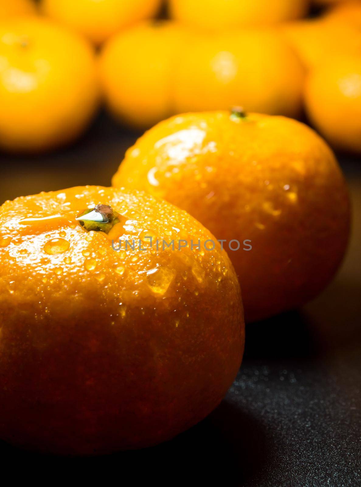 Close-up of Water droplet on glossy surface of freshness orange on black background