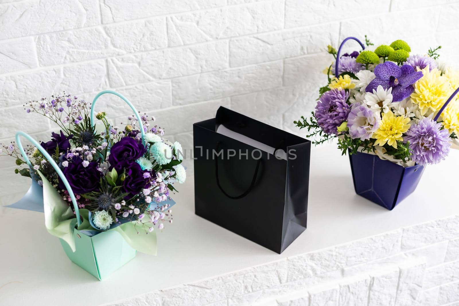 black empty paper bags and bouquets. Blank wall by Andelov13