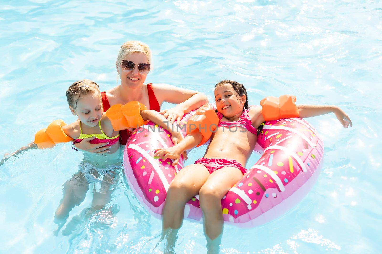 Happy family playing in swimming pool. Summer vacation concept.