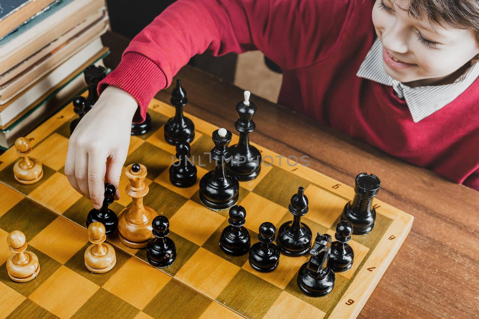 Happy kid defeating a queen figure while playing chess