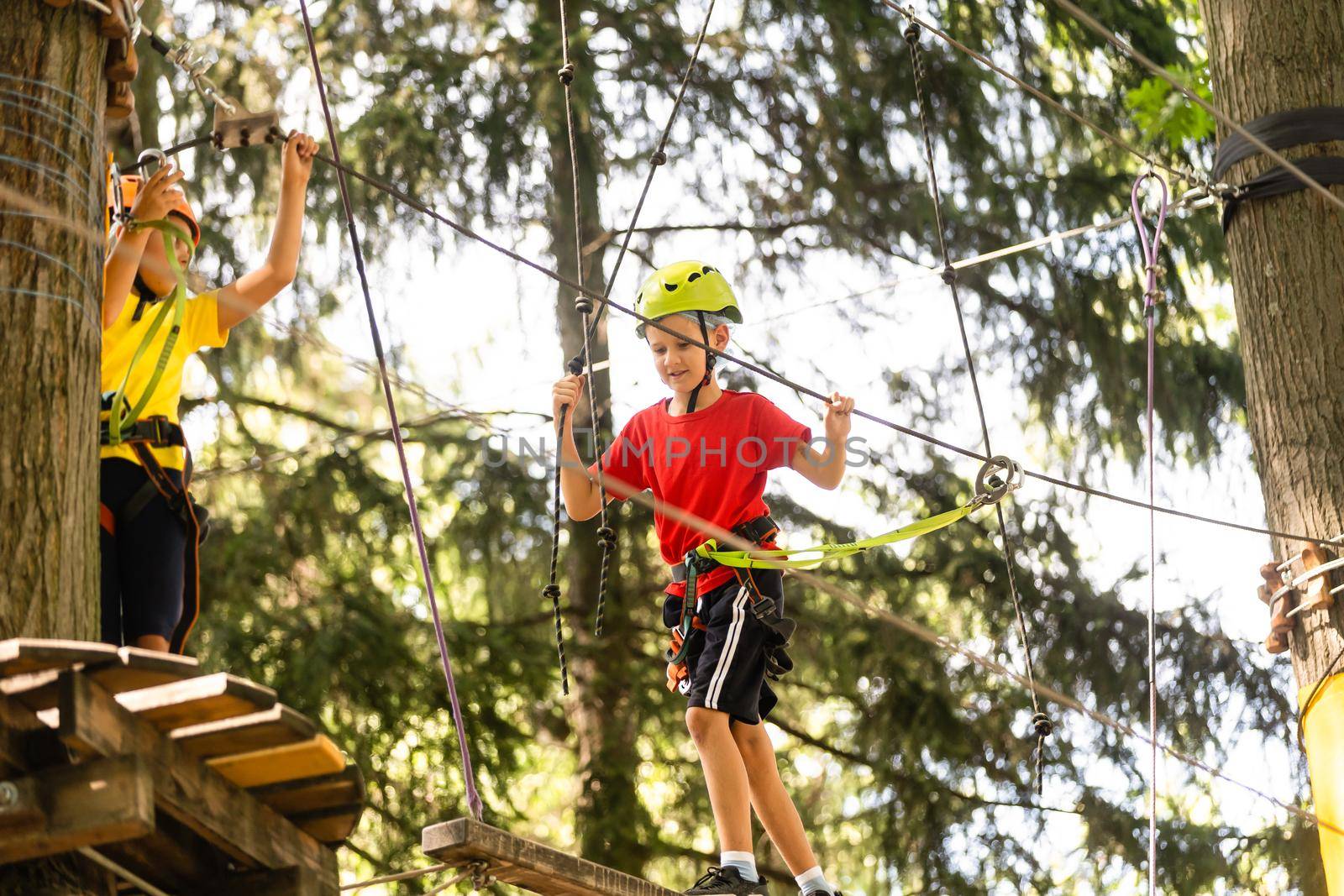 Boy climber walks on the rope bridge