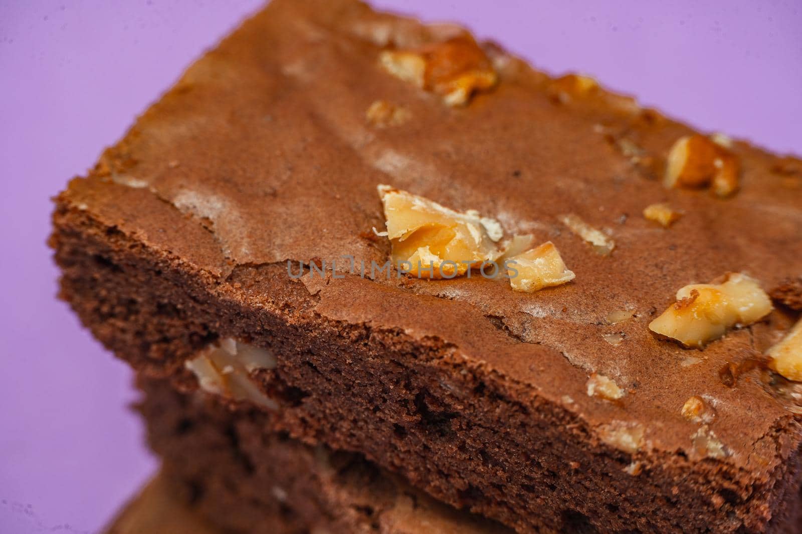 Homemade chocolate brownie squares with pecan pieces. Orange Background. Natural, healthy food concept. High view.