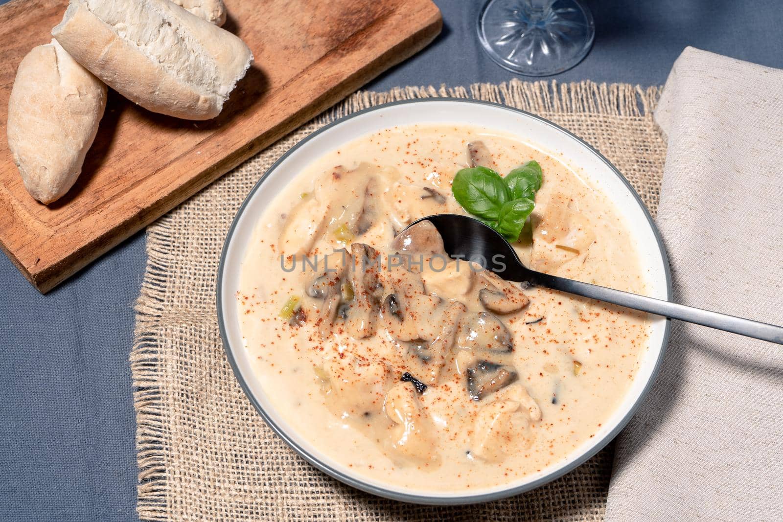 A Homemade cream of chicken and mushroom soup or French style chicken fricassee, in a soup bowl on a wooden table. Aerial view