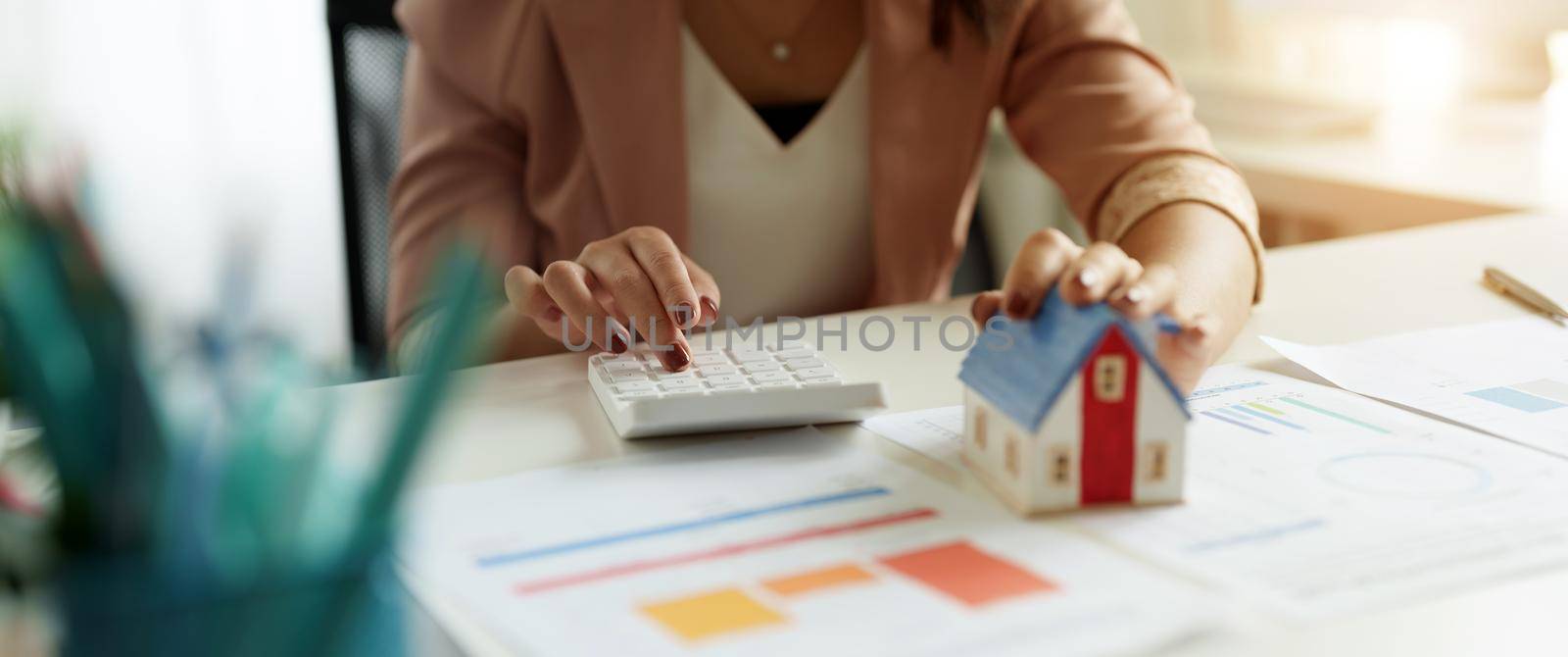 Businesswoman working doing finances and calculation cost of real estate investment while be signing to contract, Concept mortgage loan approval.