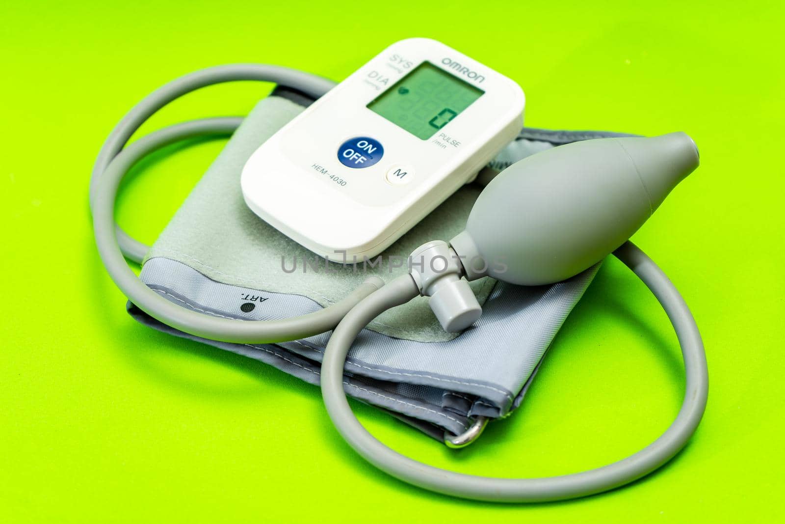 Automatic blood pressure monitor or blood pressure meter on green background. Medical equipment. by hdcaputo