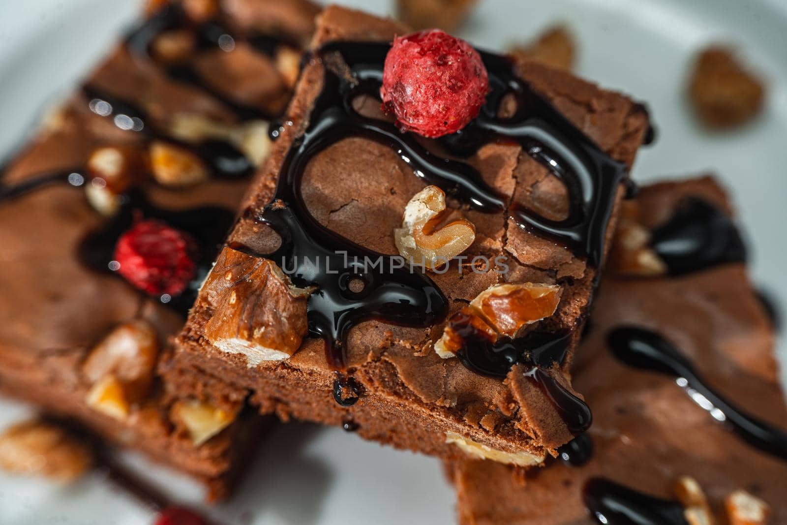 Close-up of homemade chocolate brownies squares with walnut pieces, chocolate strands and granola. Natural, healthy food concept.