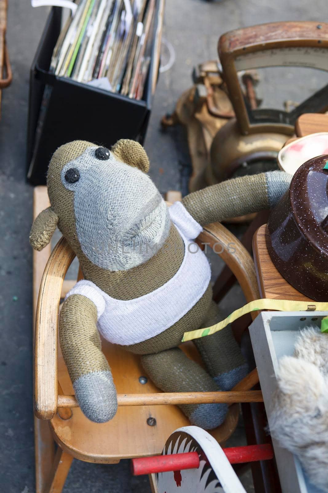 London, UK - 17 June 2019, Knitted monkey in a vest sits on a high chair on display Spitalfields vintage market