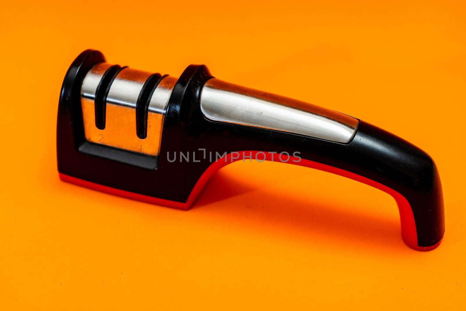 Knife sharpener isolated on an orange background.