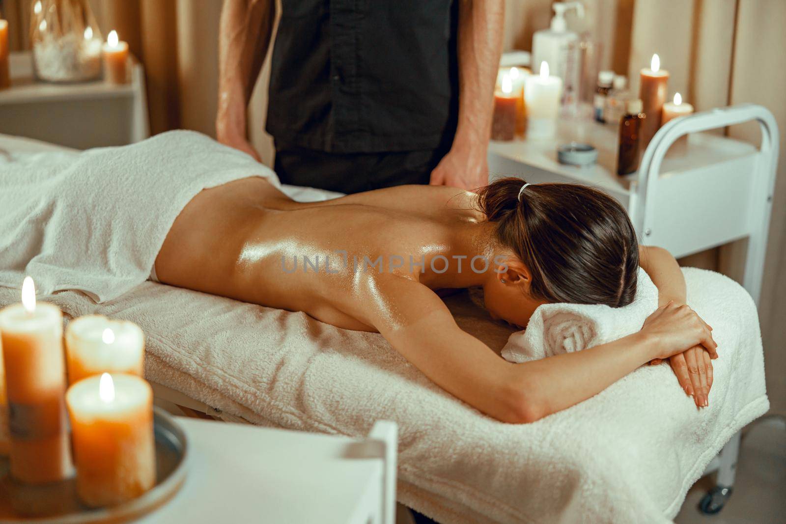 Half naked relaxed woman ready for back massage at beauty spa resort by Yaroslav_astakhov