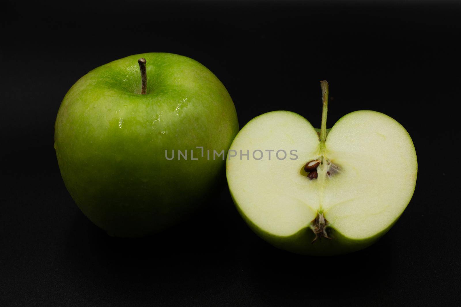 Fresh green apple and sliced isolated on black background art abstract concept.