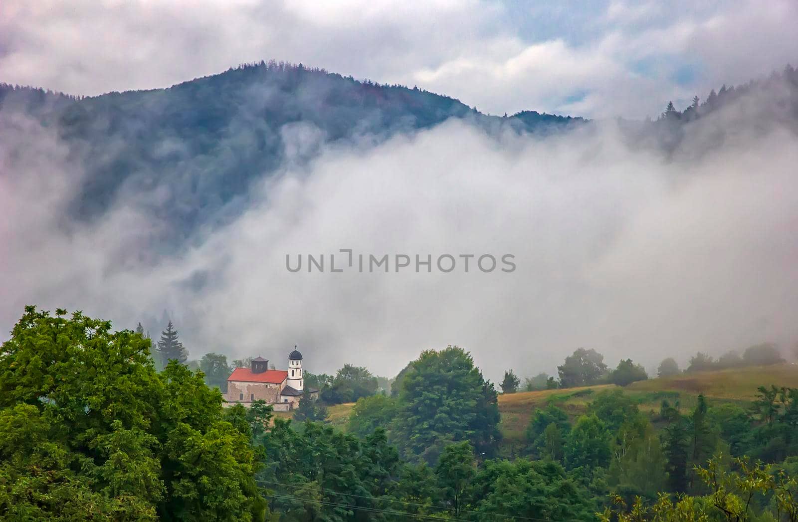 beauty mountain landscape with alone building and mist over the mountain