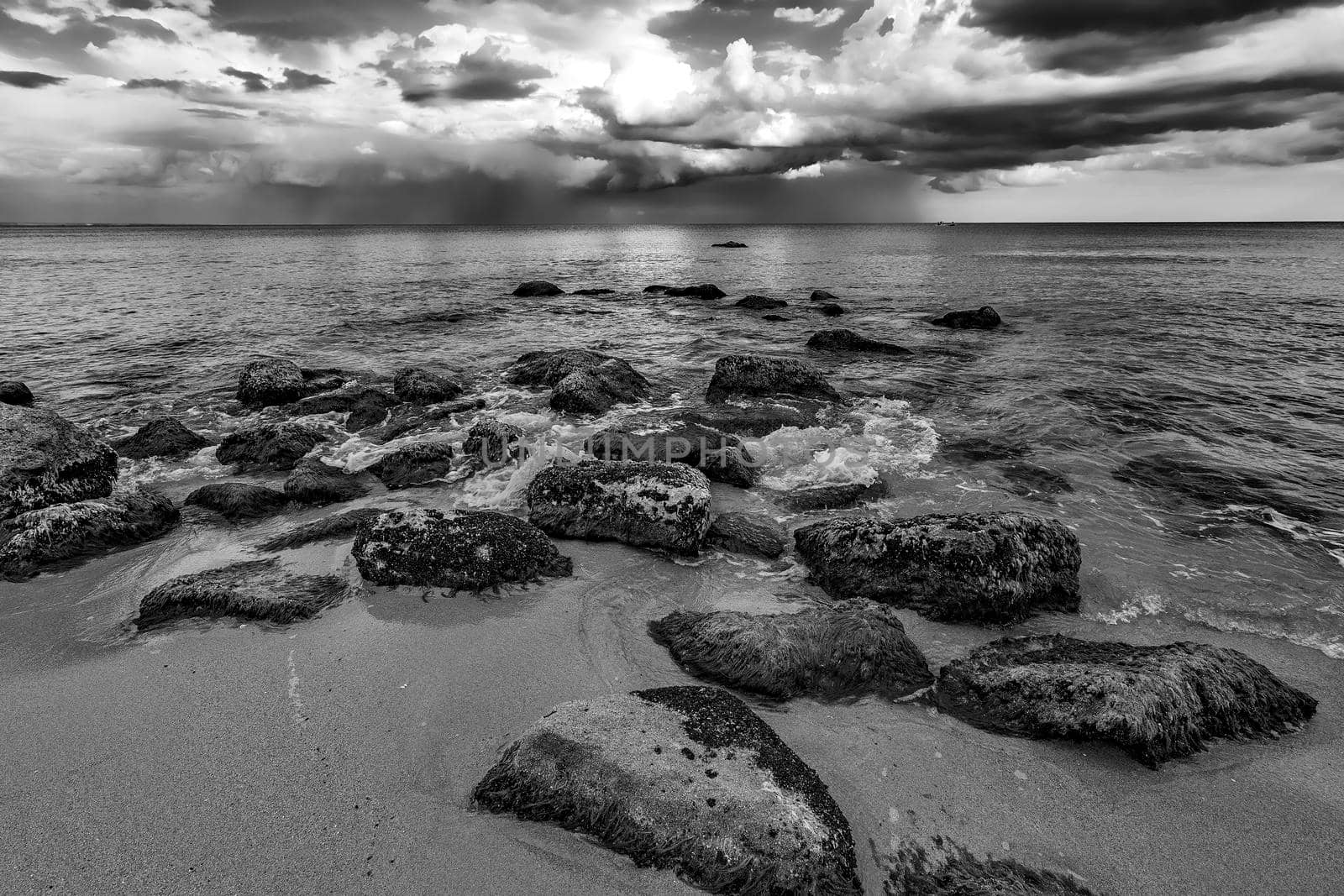 A stunning cloudy day view with the rocky sea coast in black and white