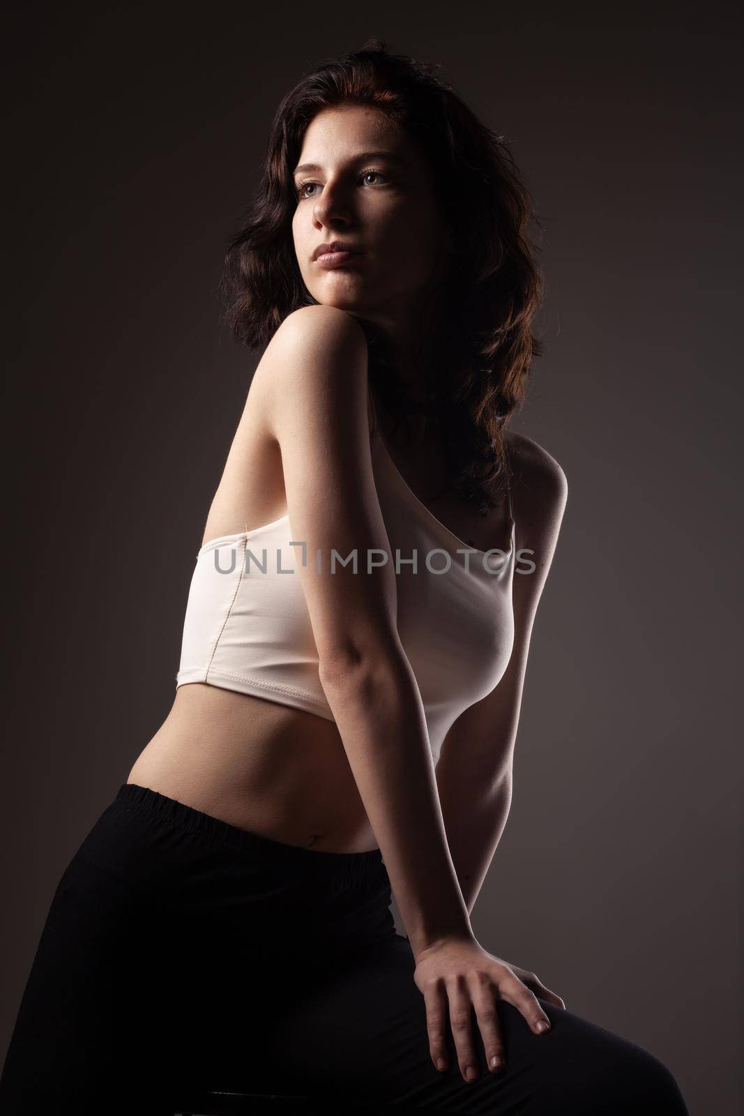 Beautiful teenage girl studio portrait against dark background.. by kokimk
