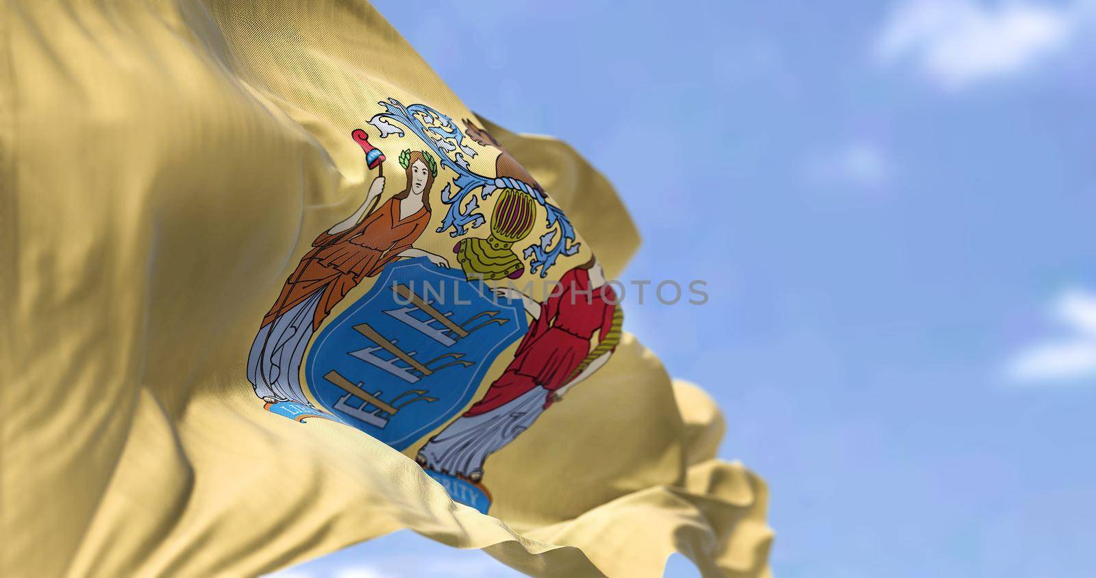 The US state flag of New Jersey waving in the wind. New Jersey is a state in the Mid-Atlantic and Northeastern regions of the United States. Democracy and independence.