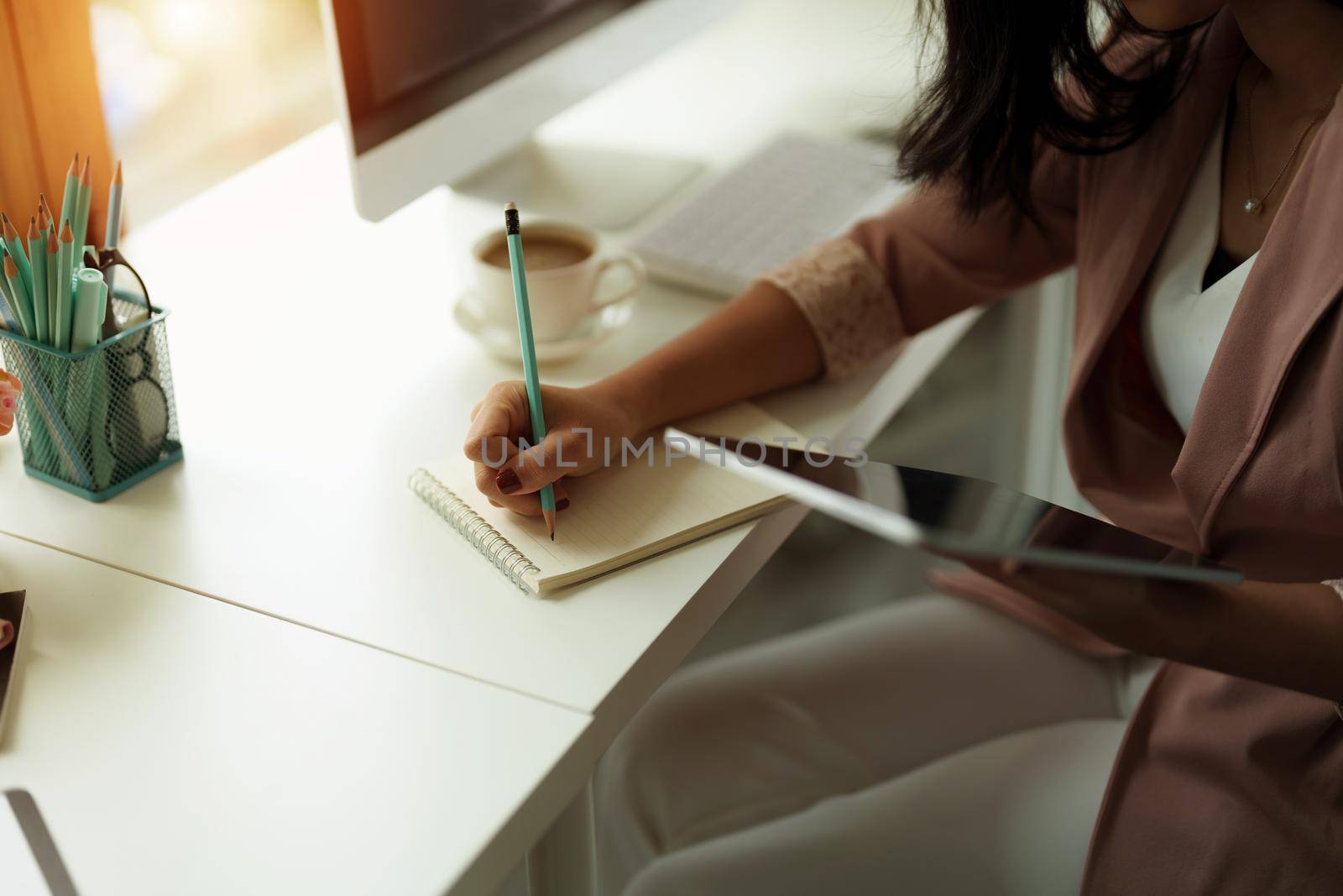 Cropped photo of woman writing making list taking notes in notepad working or learning on laptop indoors- educational course or training, seminar, education online concept.