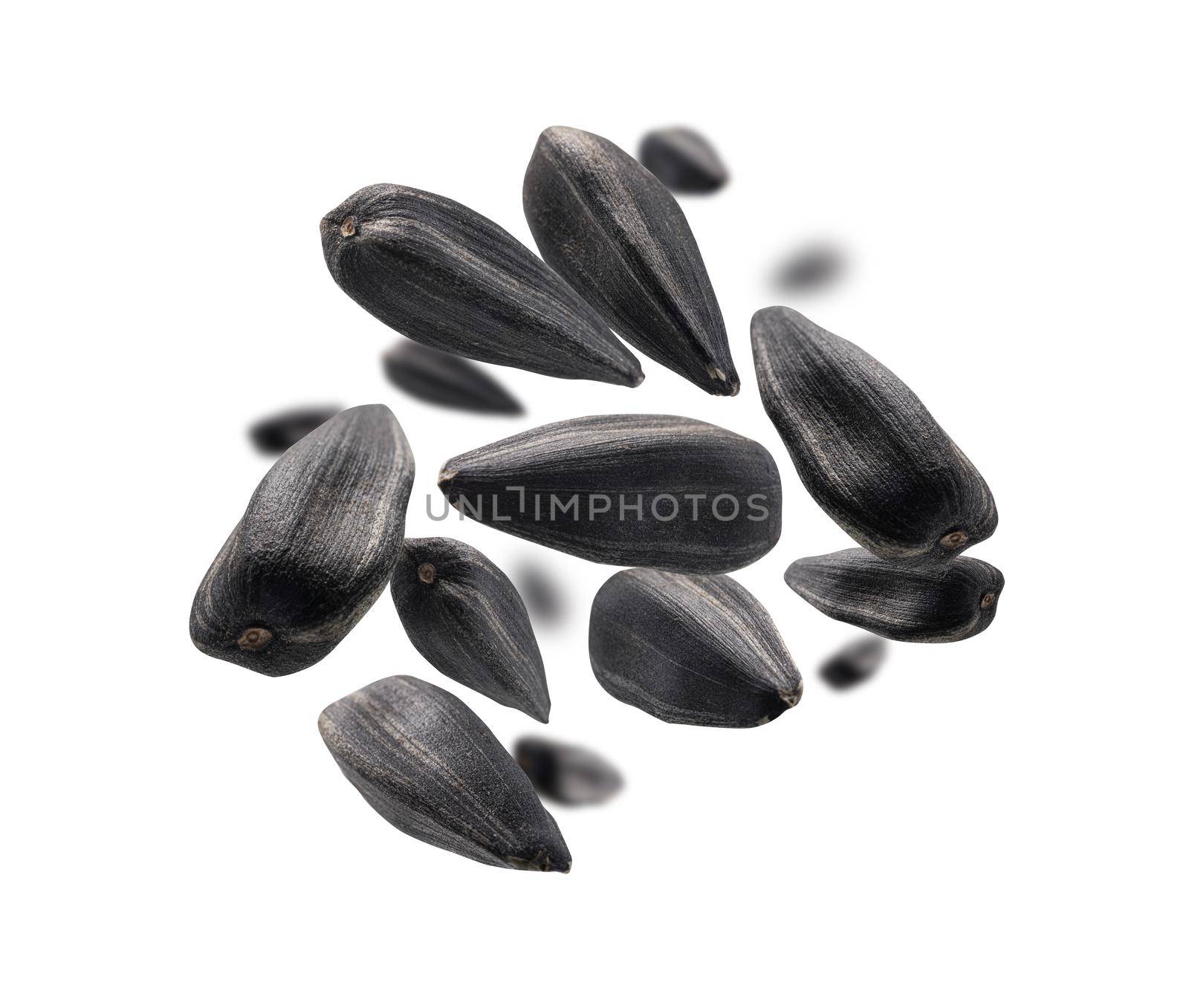 Sunflower seeds levitate on a white background.