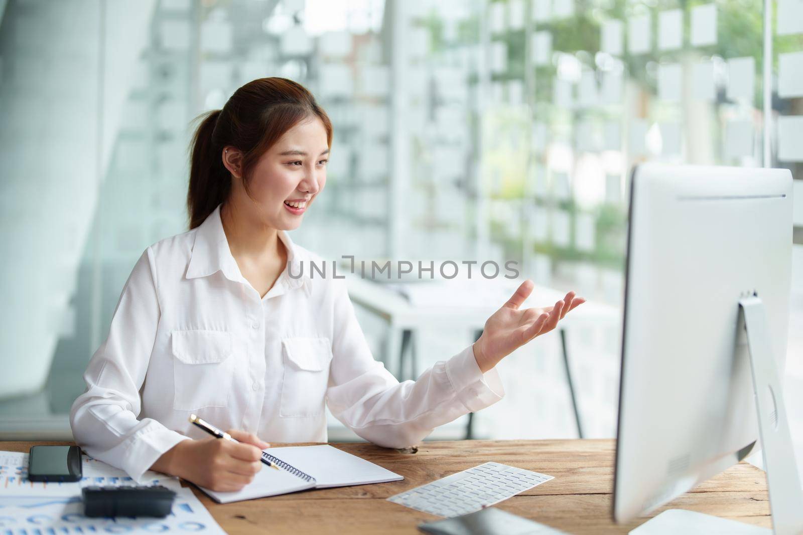 Data analysis, roadmap, marketing, accounting, auditing. Portrait of Asian businesswoman using computer in video conferencing, presenting marketing plan using statistical data sheet at work