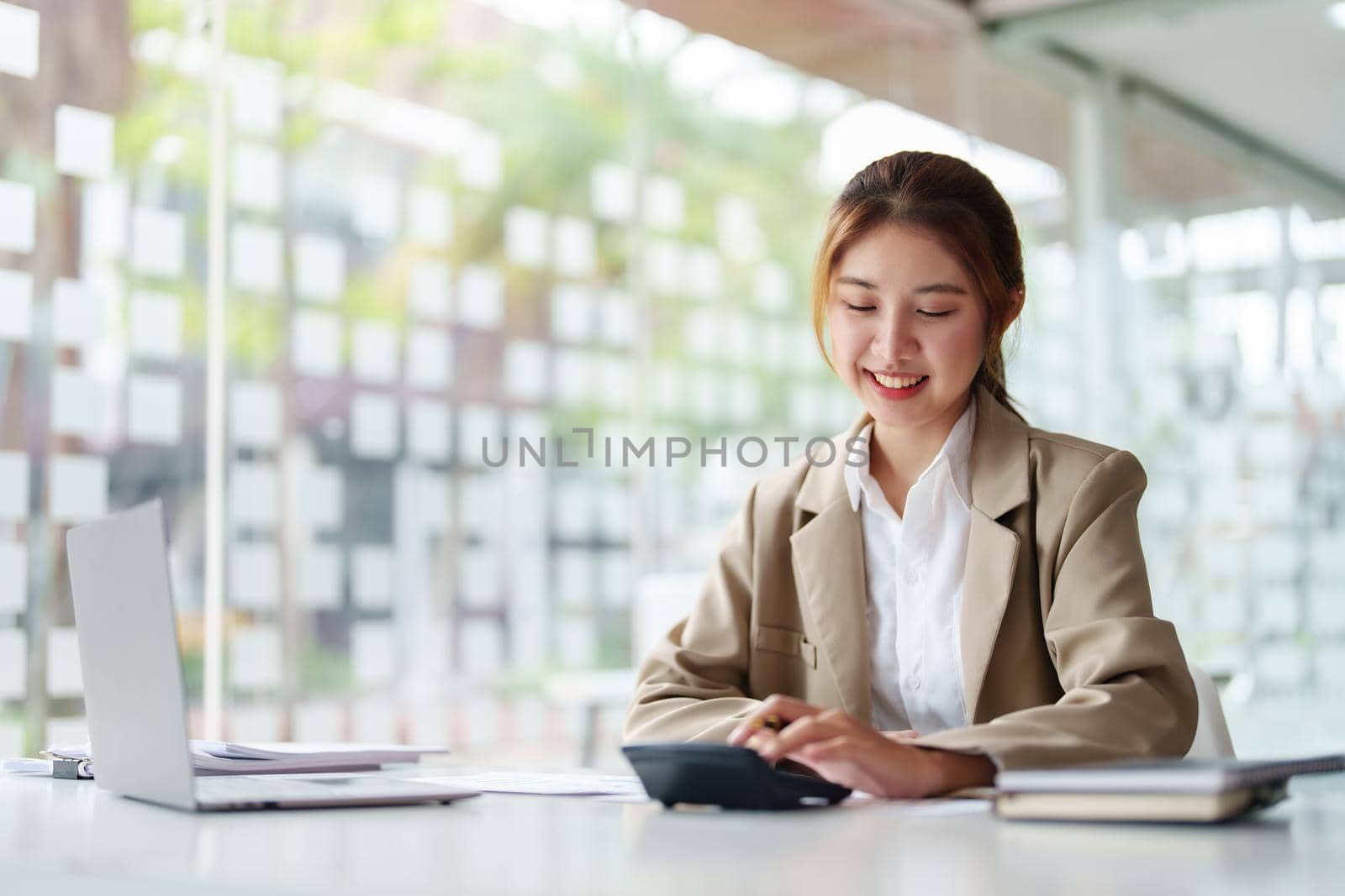 accountant, Auditor, Self-Employed, Finance and Investment, tax calculation and budget, Portrait of Asian female entrepreneur using a calculator to calculate. Company business results document. by Manastrong