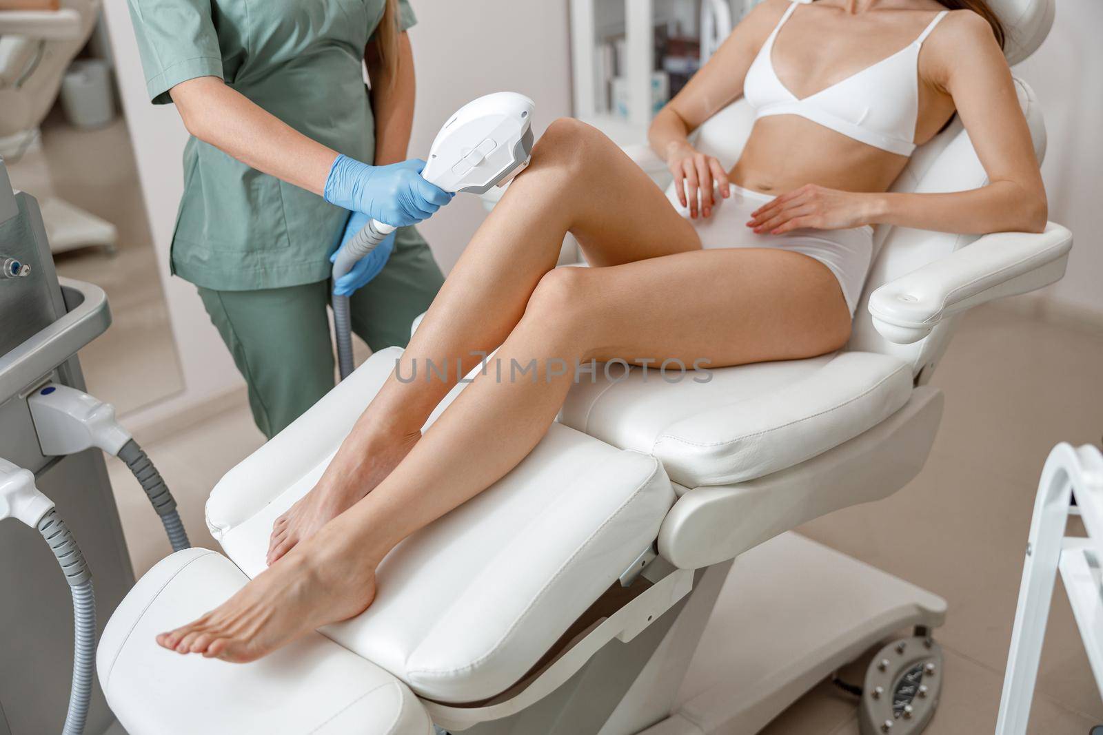 Photo epilation, hair removal procedure on legs skin in beauty salon. Woman in underwear