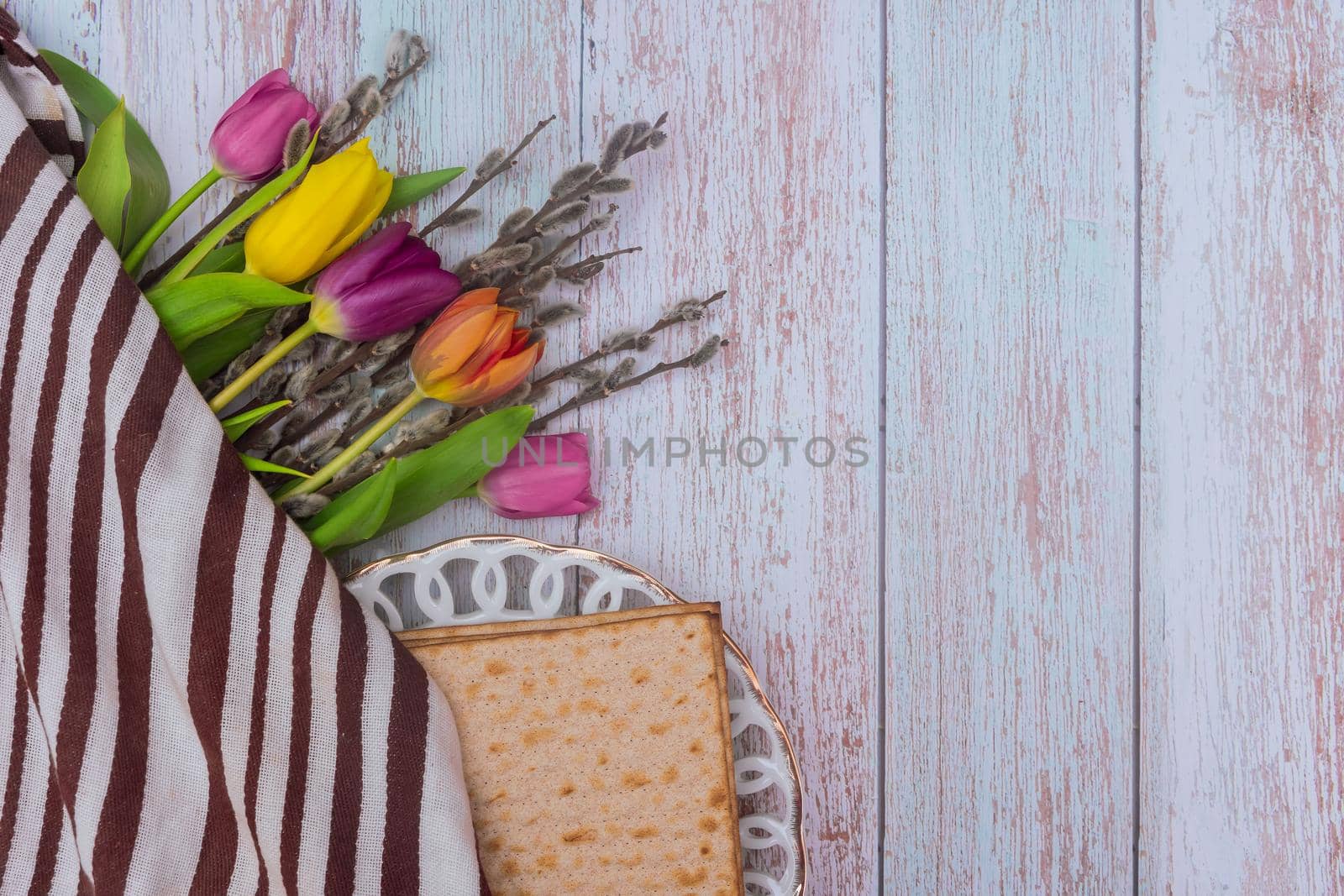 Passover Jewish holiday on flowers and matzah the wood table