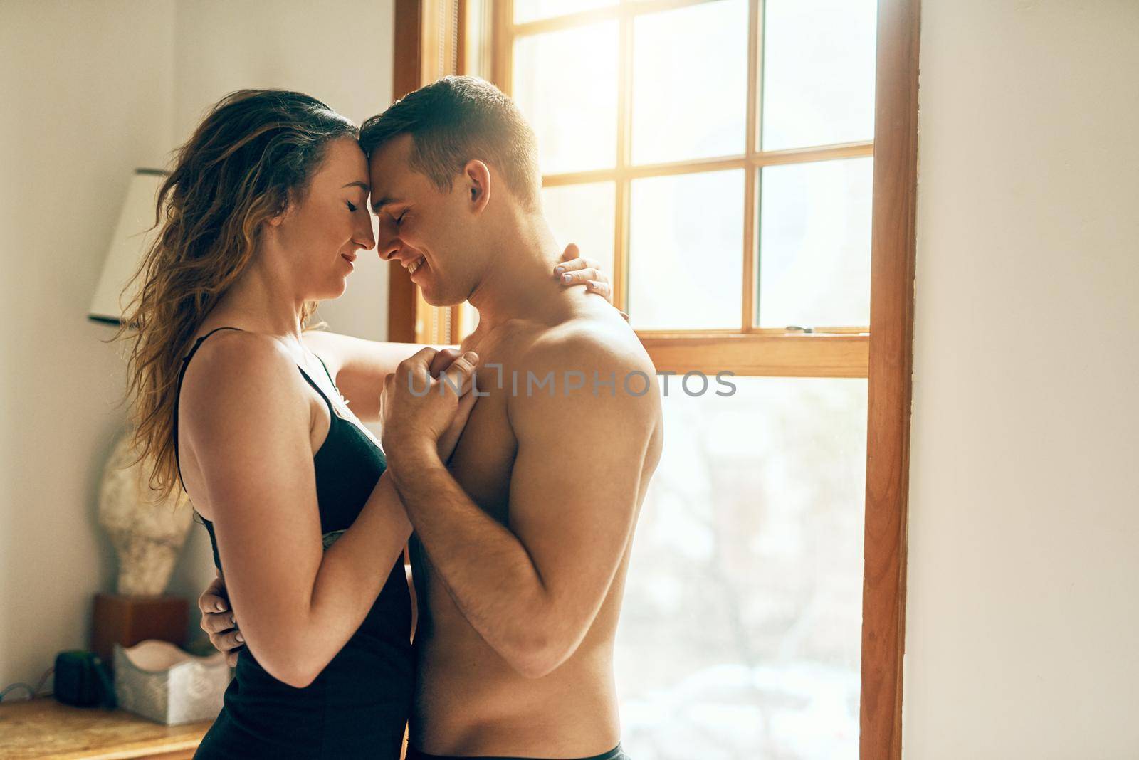 Romance in the A.M.. Shot of an affectionate young couple spending a romantic morning together at home. by YuriArcurs