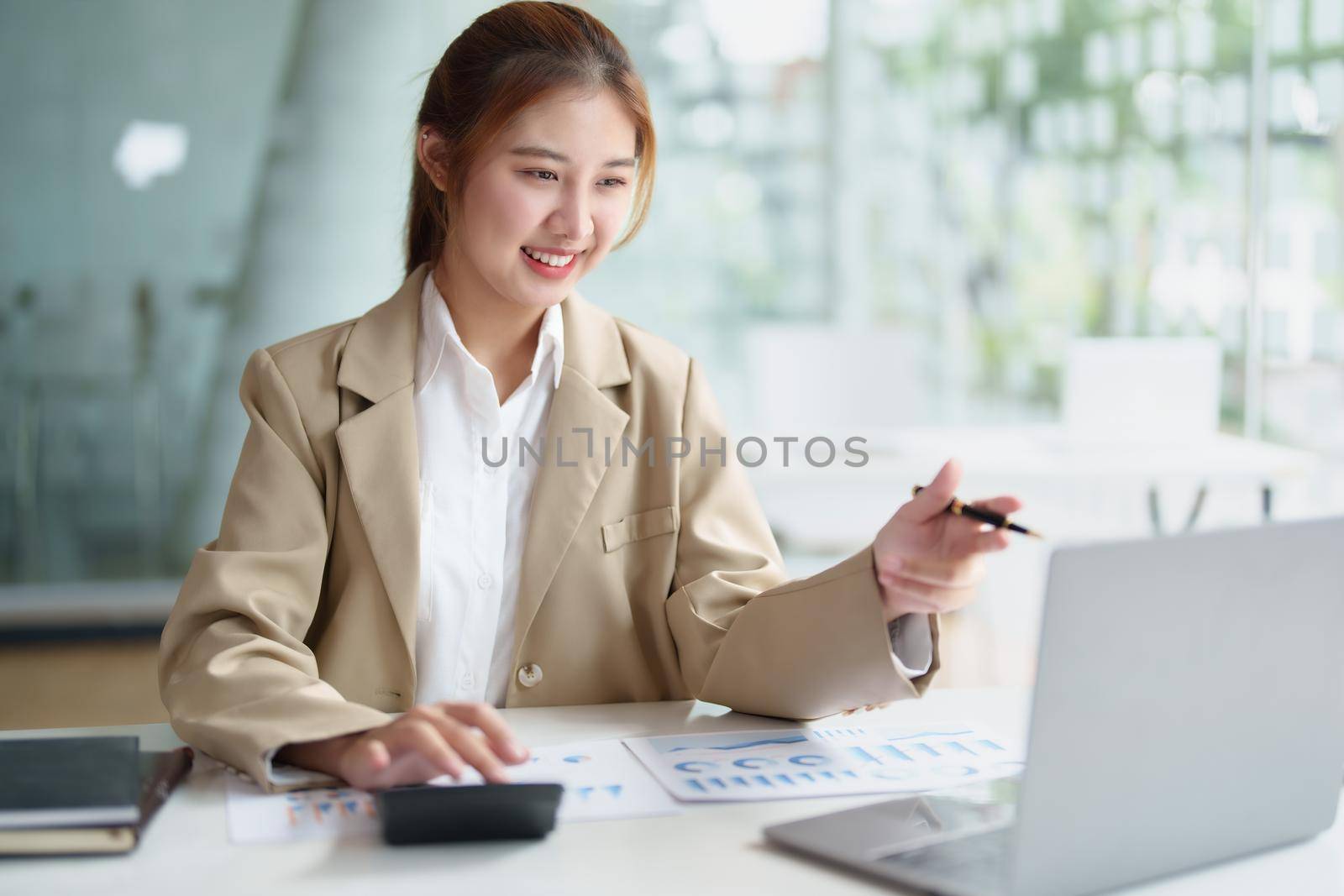 Data analysis, roadmap, marketing, accounting, auditing. Portrait of Asian businesswoman using computer in video conferencing, presenting marketing plan using statistical data sheet at work. by Manastrong