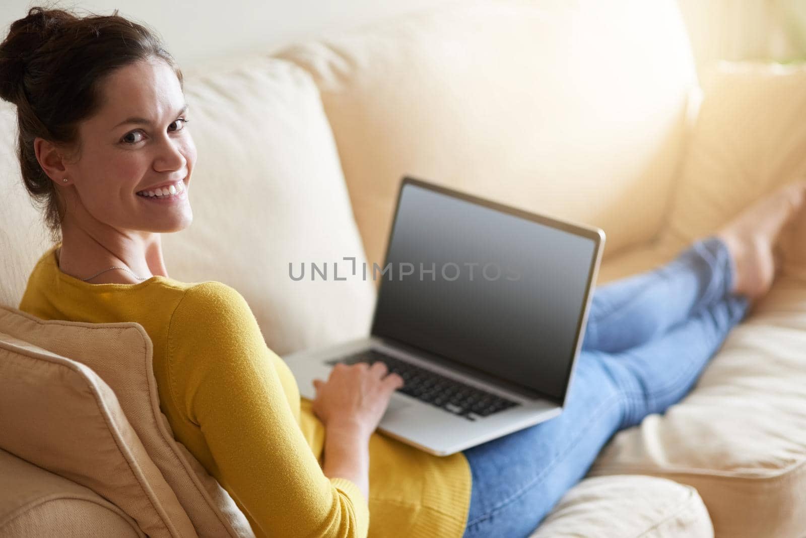 Shot of an attractive young woman using her laptop on the sofa at home.