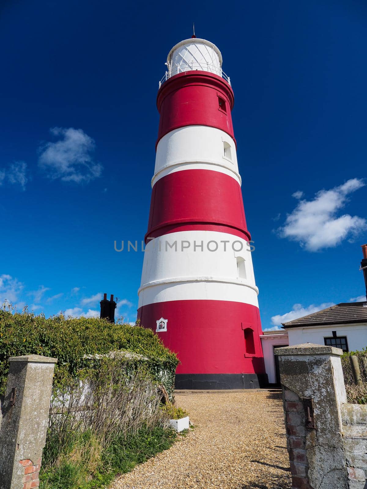 Red and white striped Happisburgh Lighthouse under blue sky and clouds, Norfolk by PhilHarland