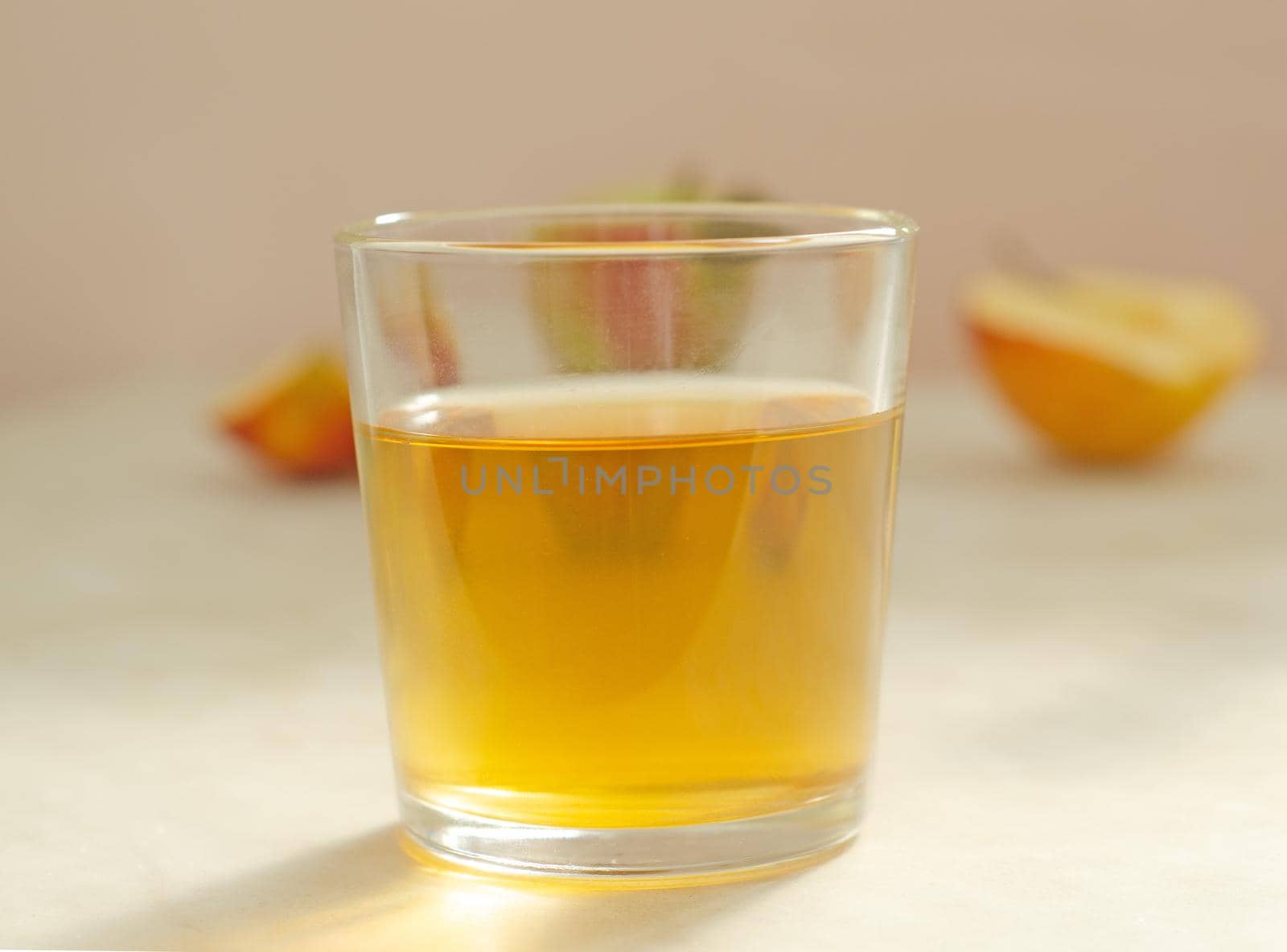 a glass of apple juice on the background of apples