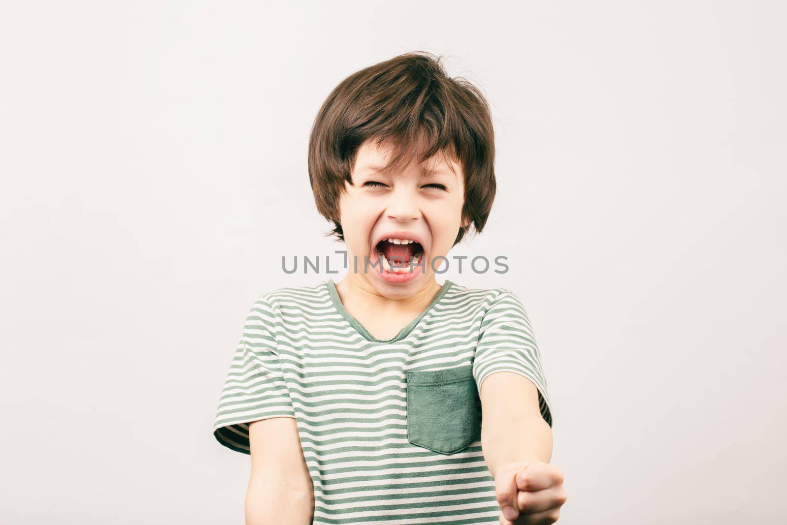 Aggressive little boy shouting with risen fist by Syvanych