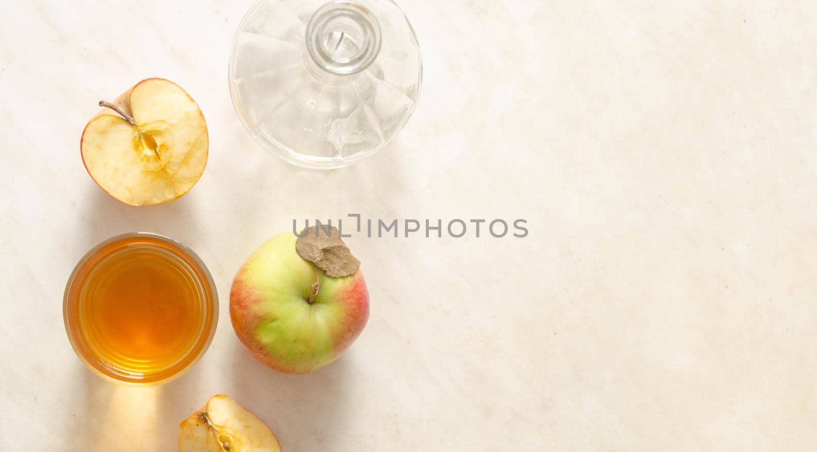 a glass of apple juice, apples and empty decanter on a white background.Top view,copy space