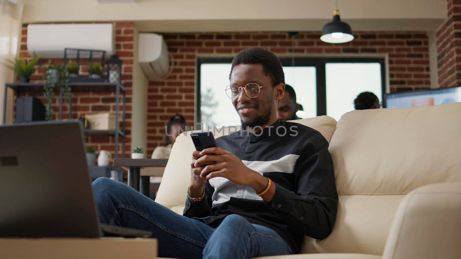 Office worker sending text messages on social media using mobile phone, using technology to browse internet and work on analysis. Male employee holding smartphone. Tripod shot.