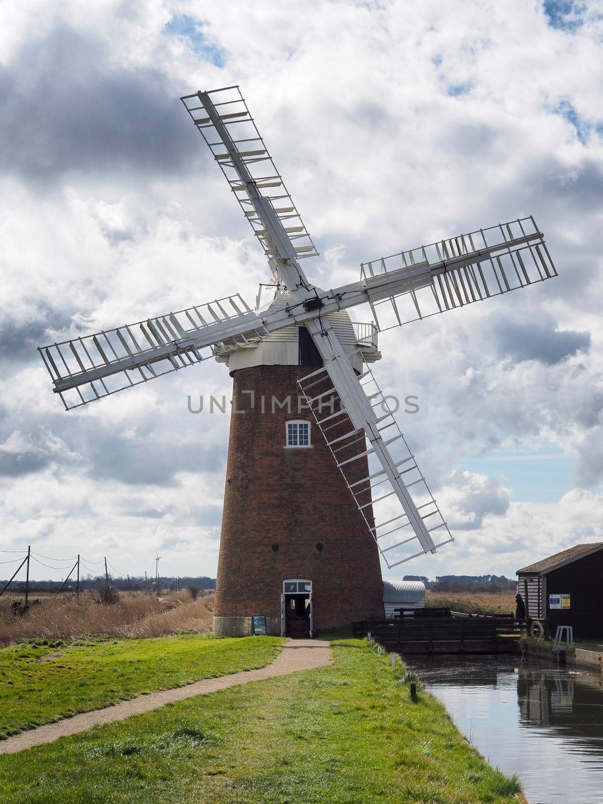 The sails of Horsey Windpump against a blue sky with white clouds, Norfolk by PhilHarland