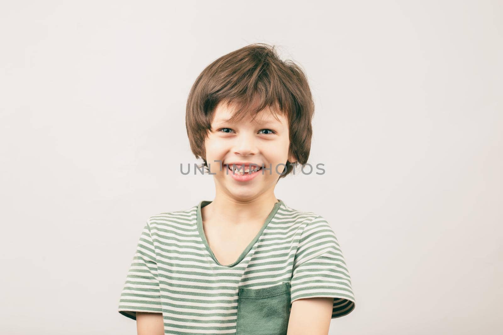 Happy six year old European boy portrait over grey by Syvanych