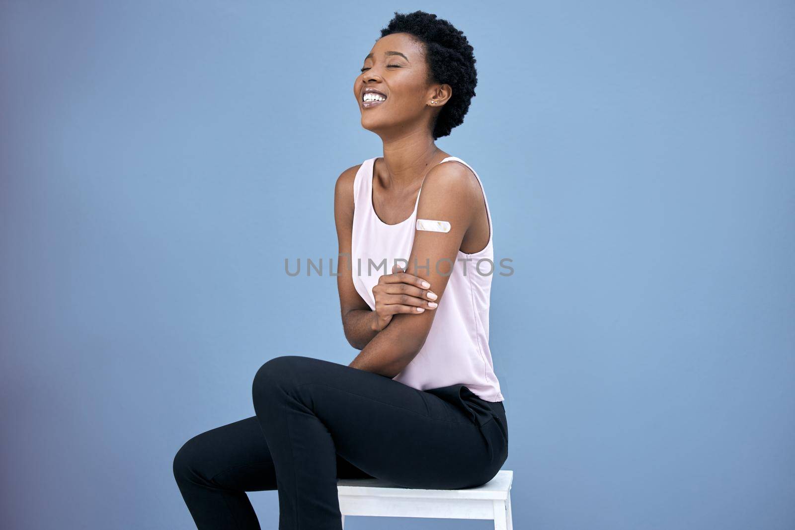 Shot of an attractive young woman sitting alone in the studio after getting her Covid vaccine.