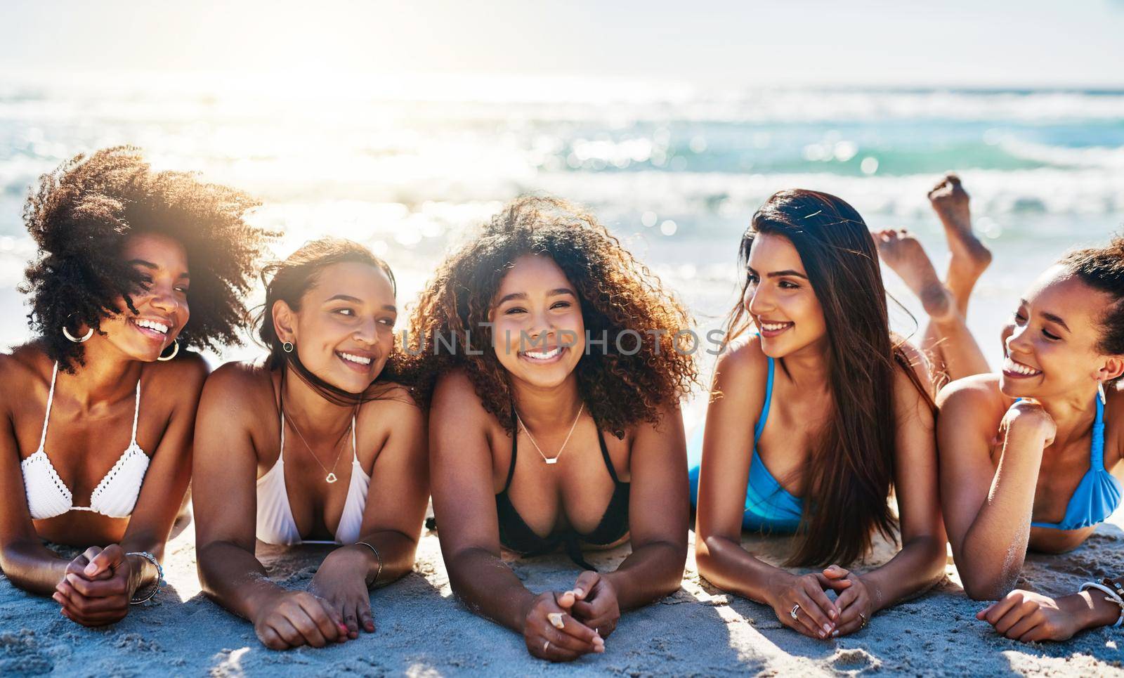 Portrait of a group of happy young women relaxing together at the beach.