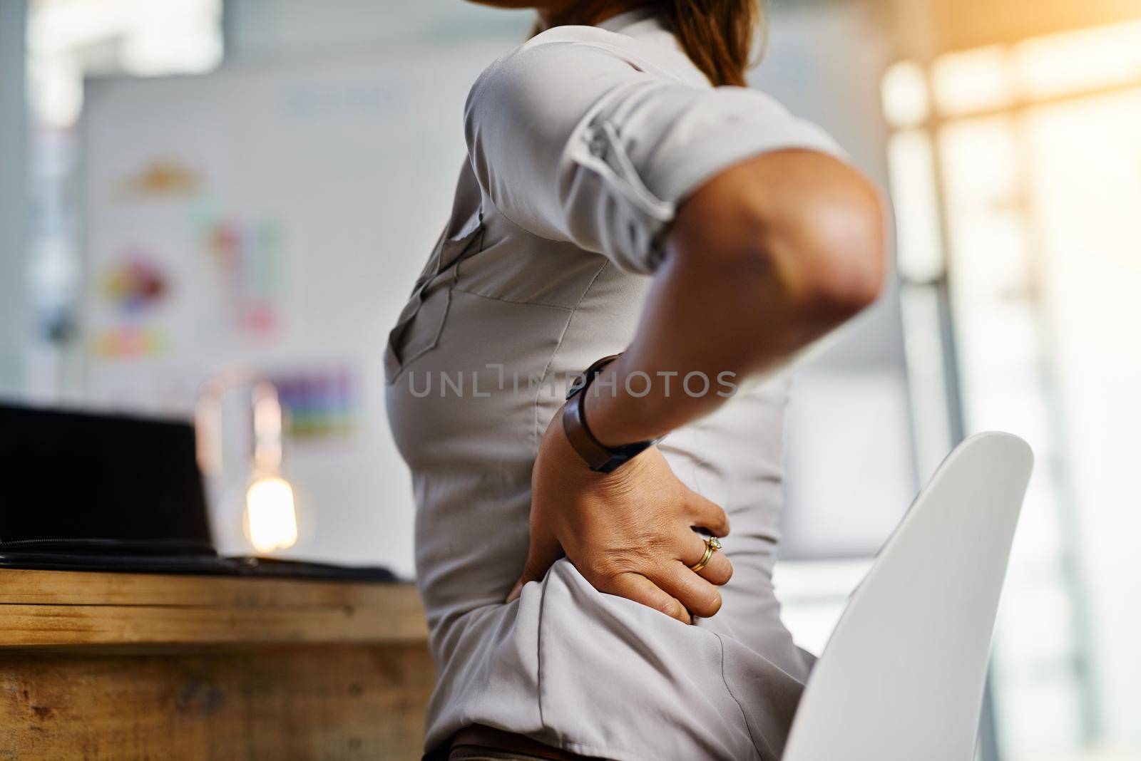 This pain has become worse. Cropped shot of a businesswoman experiencing body discomfort in the office. by YuriArcurs