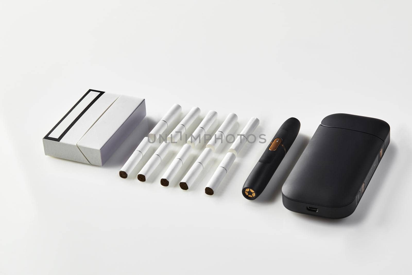 New generation black electronic cigarette and battery, one pack and ten heatsticks isolated on white. New technology. Heating tobacco system. Template place for your text, image. Close up