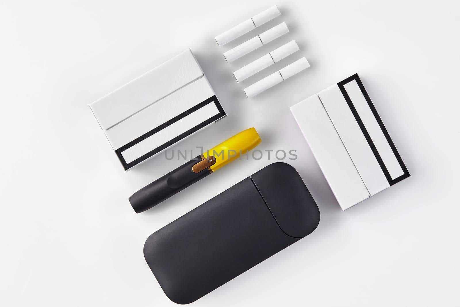 New generation black and yellow electronic cigarette, battery, two packs and four heatsticks isolated on white. Heating tobacco system. Close up by nazarovsergey