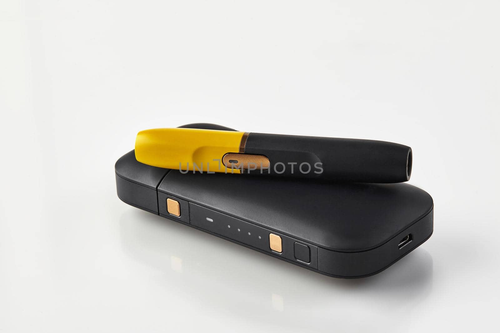 New generation black and yellow electronic cigarette is on battery, isolated on white. Hi-tech heating tobacco system. Hybrid between analog and electronic. Advertising, close up, copy space