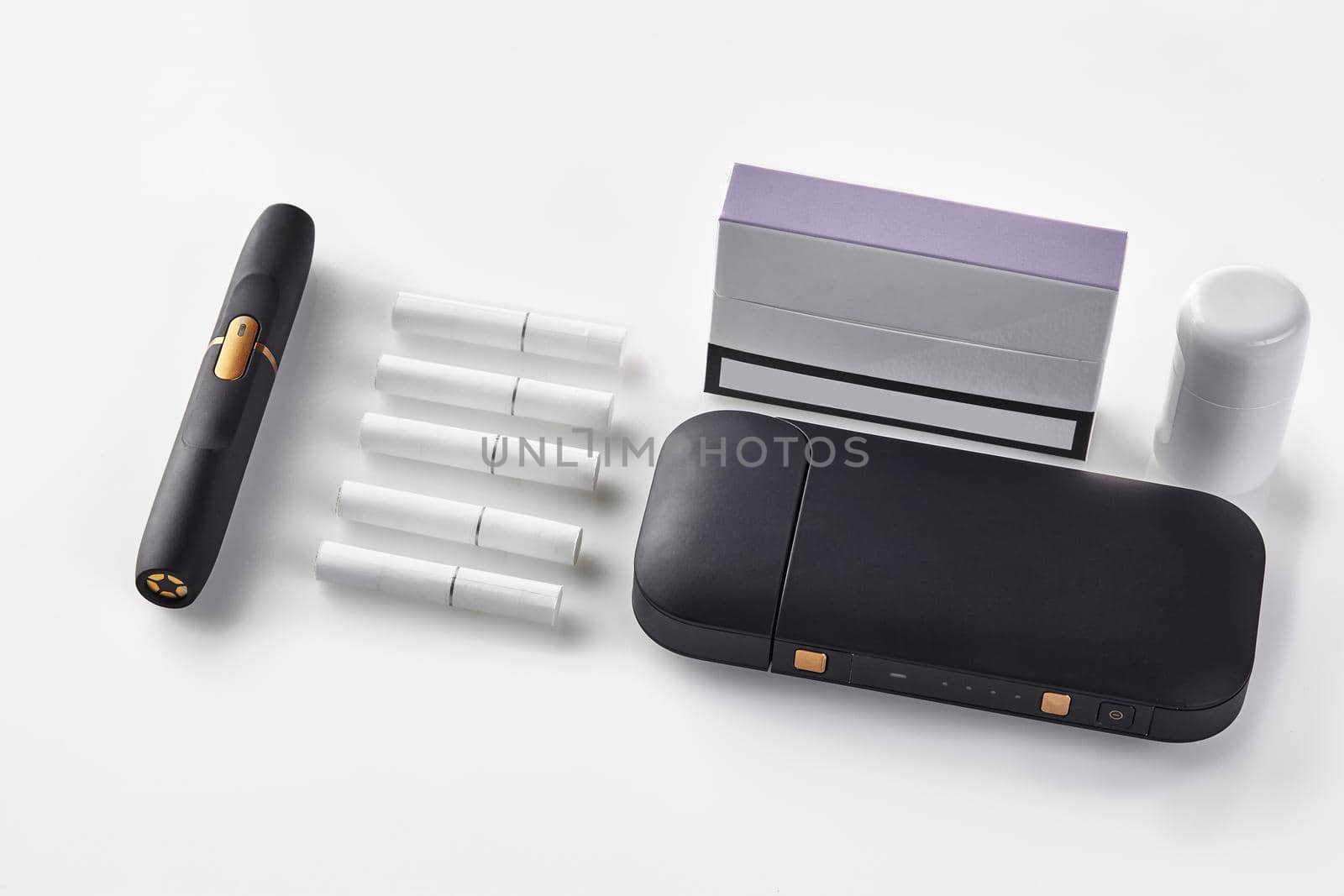 New generation black electronic cigarette battery, cleaner, pack with purple side, five heatsticks isolated on white. Heating tobacco system. Close up by nazarovsergey