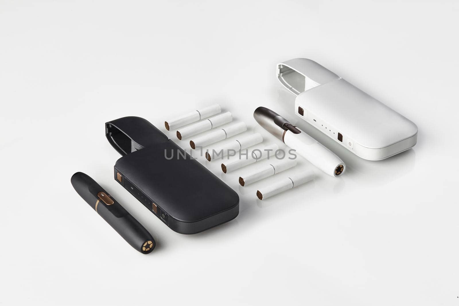 New generation, black and white, two electronic cigarettes and two open batteries, seven heatsticks isolated on white. New alternative technology. Heating tobacco system. Workspace mock up. Close up