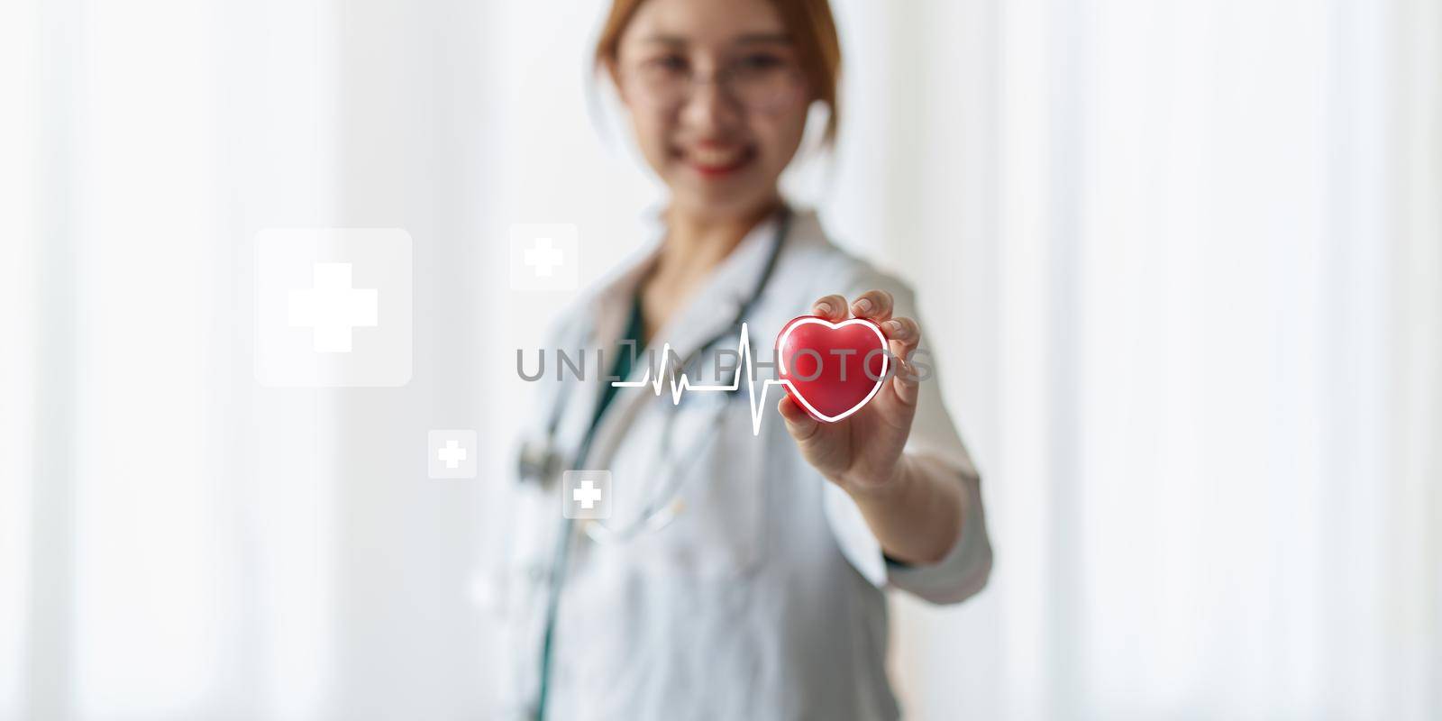 Cardiologist holding red heart in private clinic. Medical technology diagnostics of heart concept