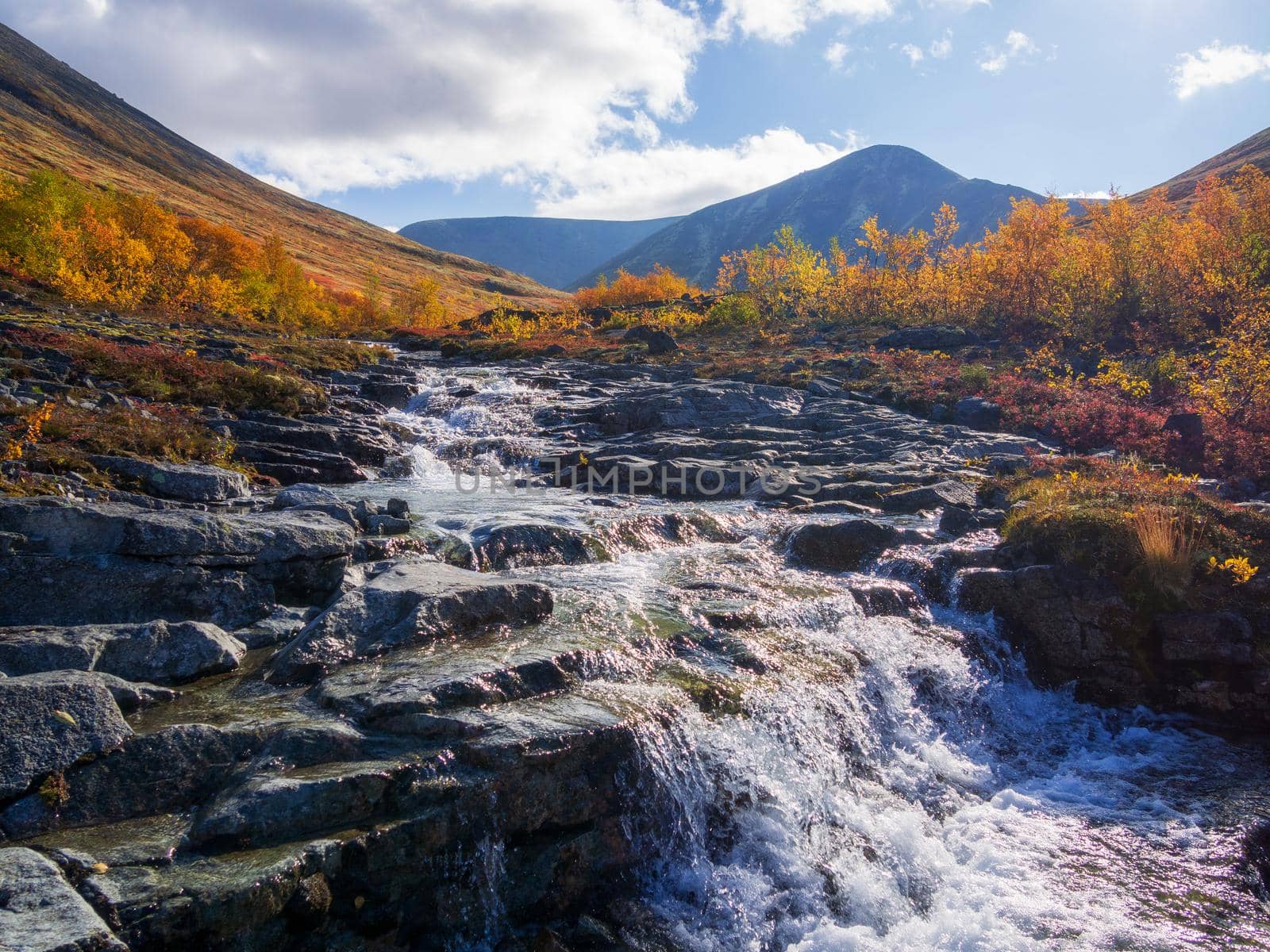 Beautiful mountain waterfall among rocks in polar summer in Khibiny Mountains. Kola Peninsula, Arctic, polar summer. photo