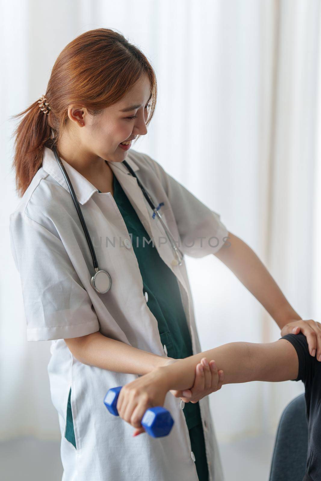 Woman doing the Rehabilitation therapy pain in clinic. Doctor or Physiotherapist. Doctor or Physiotherapist examining treating injured arm and shoulder