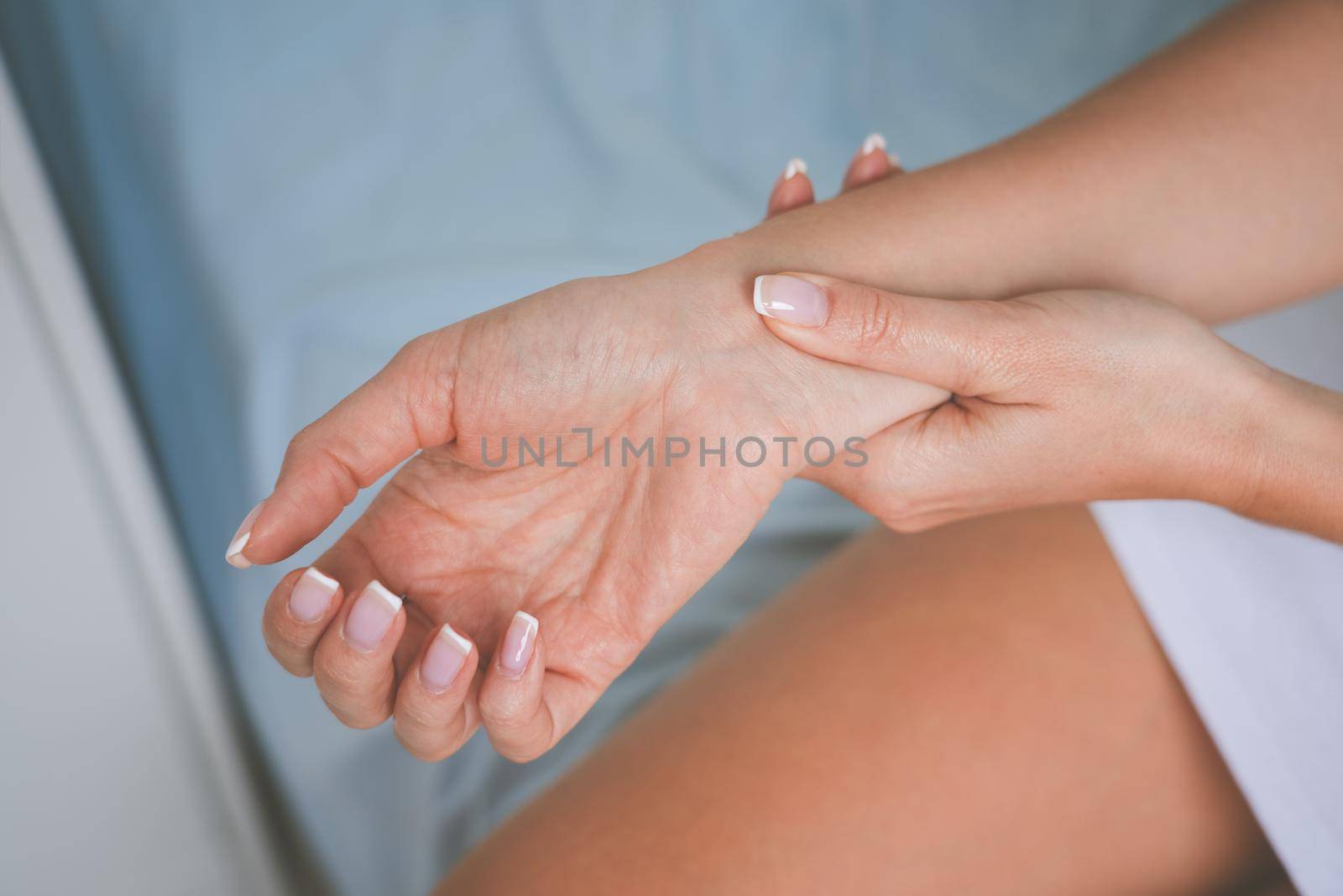 Woman massaging wrist or hand with carpal tunnel syndrome and numbness. High quality photo