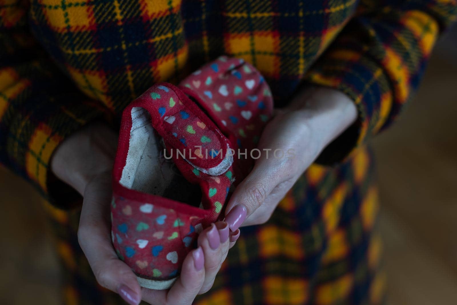 Childrens slippers in mothers hands. War in Ukraine